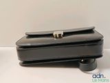 a black purse with a gold clasp on it