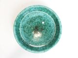 a green bowl sitting on a table with a white background