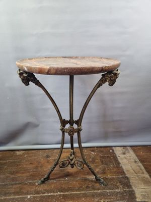 an old table with a marble top on a wooden floor