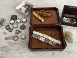 a wooden box with a watch, bracelet, and other items on it