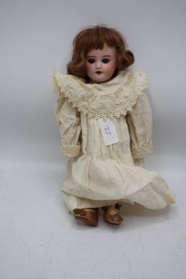 une image représentant une poupée vêtue d'une robe blanche et de chaussures dorées