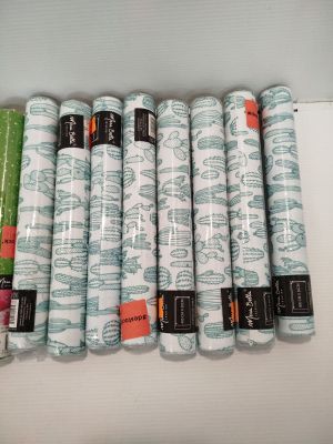 Plusieurs rouleaux de tissu sont alignés les uns à côté des autres sur une table