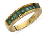 un gros plan d'une bague en or sertie d'émeraudes