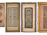 quatre morceaux de tissu brodé accrochés au mur