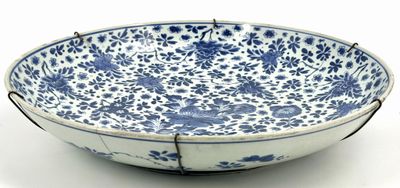blue and white bowl with floral design on it on a white surface