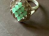 une bague ornée de pierres vertes, posée sur une table