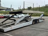 an image of a tow truck with a flat bed in a parking lot