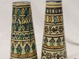 two vases that are sitting on a white surface
