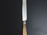 a close up of a knife on a table with a black background