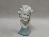 a white bust of a child on a blue base