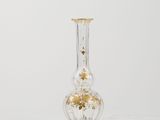 an antique glass vase with a gold leaf decoration on the base