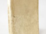 an old book sitting on top of a white surface