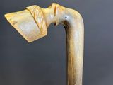 a close up of a wooden walking stick with a wooden handle