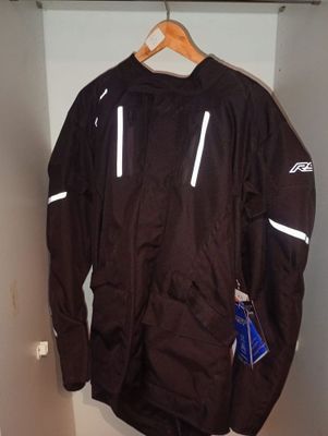 une veste noire suspendue à un portant dans un placard