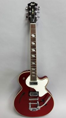 a red electric guitar hanging on a wall with a white background
