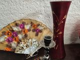 a table with a vase, a fan, a candle, and other items on it