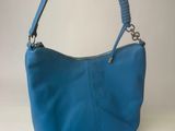 a blue purse on a white table with a chain around it