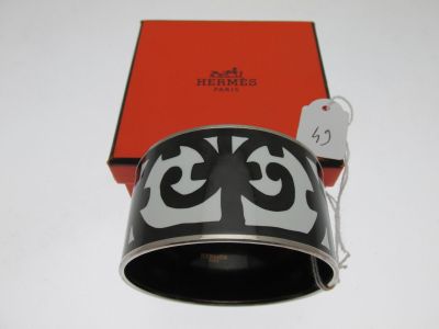 un bracelet noir et blanc avec une boîte rouge en arrière-plan