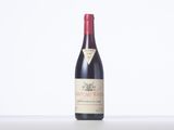 a bottle of red wine sitting on top of a white table