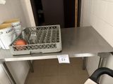 une table en métal sur laquelle est posé un panier de fruits