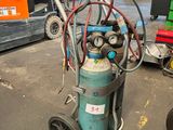un petit compresseur d'air posé sur un chariot dans un entrepôt