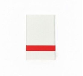 une serviette blanche ornée d'une bande rouge, posée sur une surface blanche