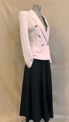 a white jacket and black skirt on a mannequin