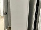 un réfrigérateur blanc au milieu d'une pièce, dont les deux portes sont ouvertes