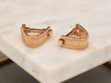 the gold plated cuff earrings are set on a marble table