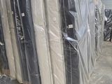 many mattresses wrapped up in plastic in a warehouse