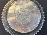 a close up of a silver plate on a black surface