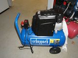 a blue air compressor sitting on the floor in a room