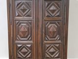 an antique wooden armoire with carved panels on top of it