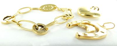 deux bracelets en or et une breloque en forme de cœur sur un fond blanc