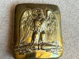 une image représentant une assiette en or sur laquelle figure un aigle