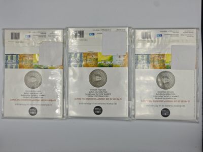 three silver coins sitting on top of each other next to each other