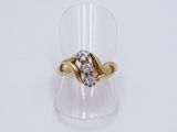 a close up of a gold and diamond ring on a clear ring holder