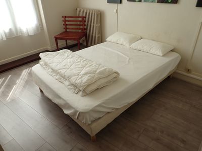 a bed with a white comforter on it in a room