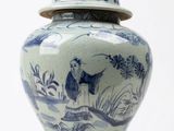 un vase bleu et blanc avec un couvercle posé sur une table