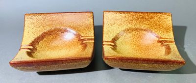 deux petits bols bruns avec des anses posés sur une table