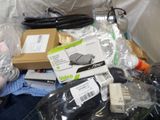 a pile of electronics and other items on a bed