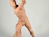 statue of a man holding a tennis racquet in his right hand