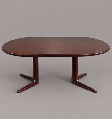 une table de salle à manger ovale avec quatre pieds et un plateau en bois