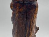an old wooden figurine of a man with a pipe in his hand