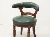 a green chair with a wooden frame and leather seat