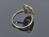 an old cut diamond and sapphire ring on a reflective surface