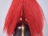a red wig that is on top of a black vase