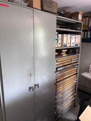 une armoire métallique comportant de nombreux tiroirs, dans une pièce