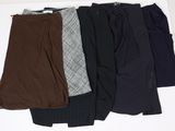 Quatre paires de pantalons pour femmes sont alignées sur une surface blanche