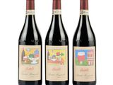 trois bouteilles de vin rouge sont posées côte à côte sur une surface blanche
